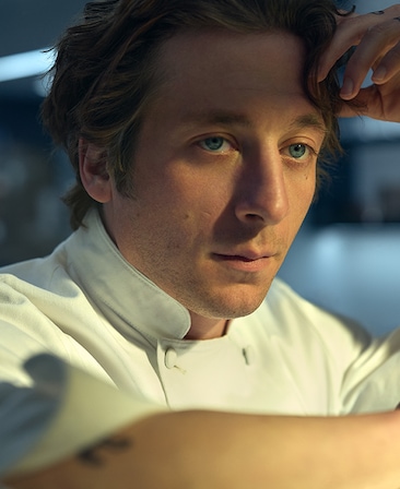 Jeremy Allen White headshot in a white chef jacket.