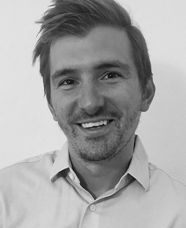Eric Kovtun black and white headshot in a light button shirt