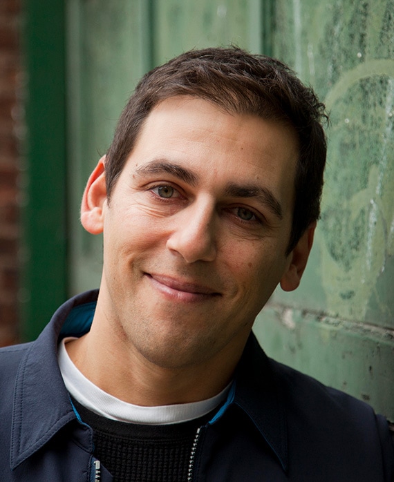 Stuart Zicherman headshot in a blue zip up with a black sweater underneath