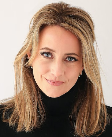Headshot of executive producer Julie DeJoie wearing a black turtleneck and small hoop earrings.