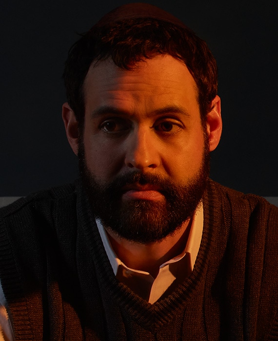 Andrew Leeds headshot wearing a white collar shirt with black sweater