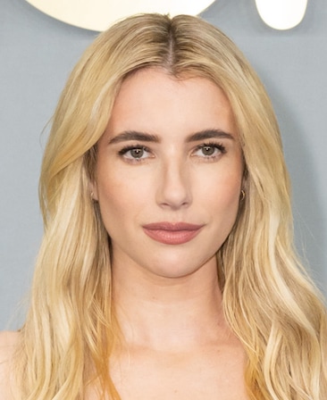 Emma Roberts headshot wearing gold earrings and pink makeup.