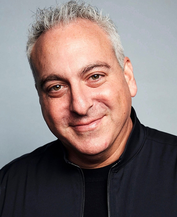 Andrew Fried Headshot wearing a black shirt and jacket