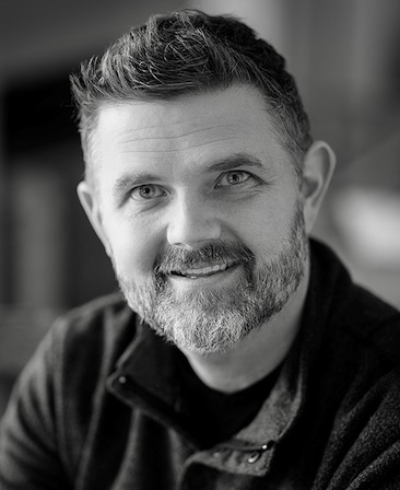Black and white headshot of Bryan Rowland in a button up shirt