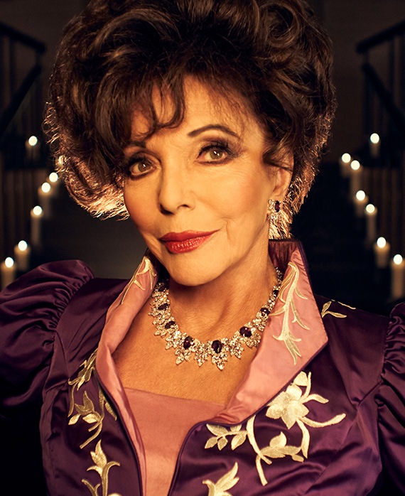 Joan Collins headshot in purple and pink dress with gold embroidery and candles in background from AHS Apocalypse