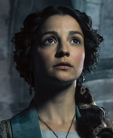 Flora Spencer Longhurst headshot looking up with hair braided with metallic ribbon in side ponytail and ancient blue robe