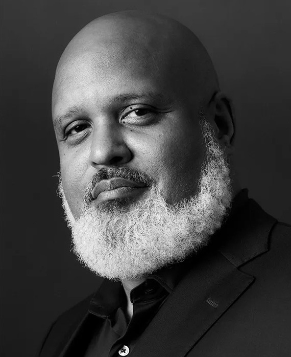 Black and white headshot of executive producer Paul Garnes wearing a suit.