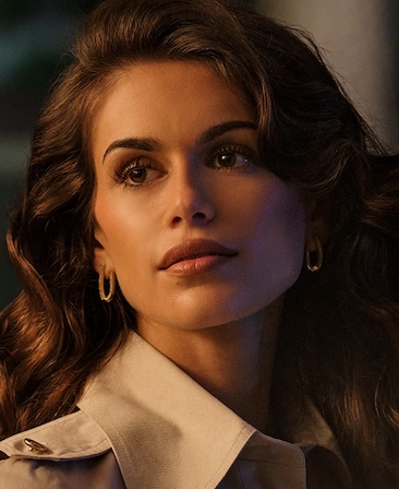 FX's The Shards Kaia Gerber as Susan Reynolds wearing gold earrings and a collared shirt.
