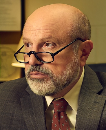 Enrico Colantoni as Principal Grant Moretti for FX's English Teacher wearing a textured suit and burgundy and printed tie.