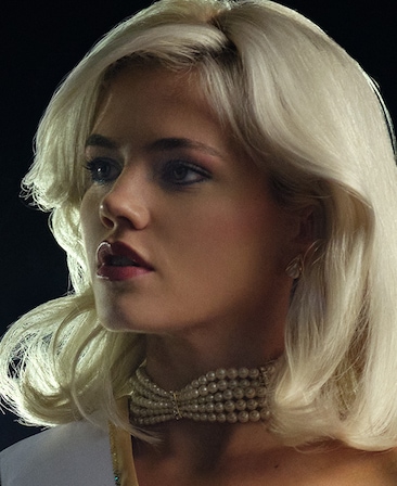 FX's The Shards Hayes Warner as Debbie Schaffer with outside with light shinning on her hair wearing pearls.