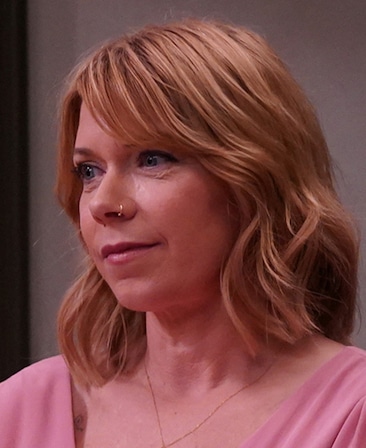 Headshot of Mary Elizabeth Ellis in FX's It's Always Sunny in Philadelphia wearing a pink shirt and gold jewelry.