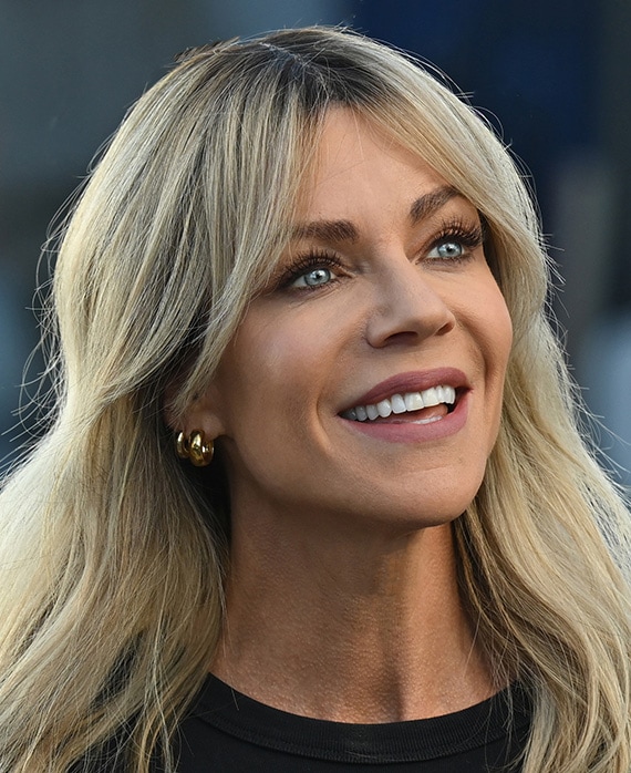 Kaitlin Olson headshot wearing black tshirt and gold earrings.