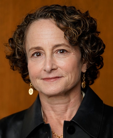 Headshot of FX's The Shards executive producer Nina Jacobson wearing a white blouse and black leather jacket.