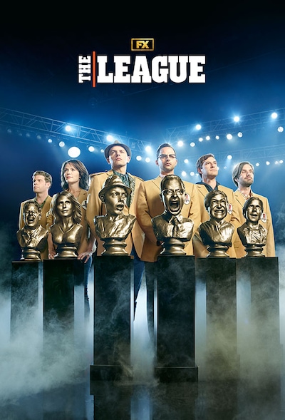 Group of friends lined on up a football field in Fantasy Football sports jackets standing behind golden busts of themselves