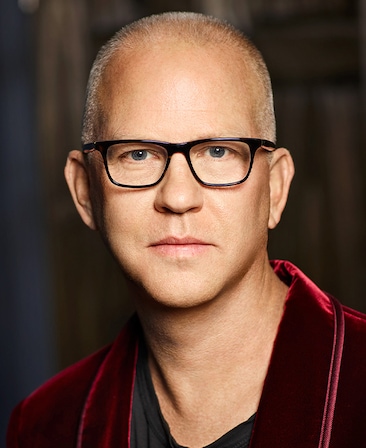 Ryan Murphy headshot wearing a red jacket and black glasses