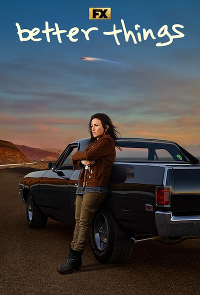 Sam in a brown suede jacket and dark clothes leaning on classic black Impala sitting on the side of the PCH for Better Things