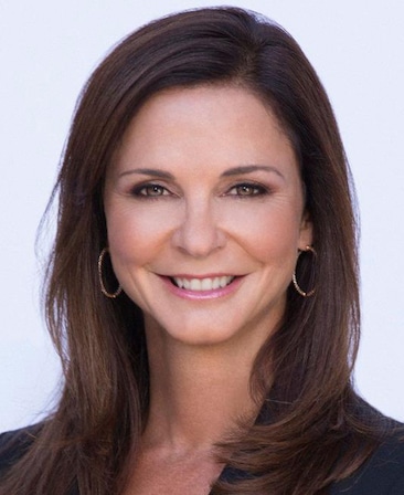 Headshot of executive producer Nissa Diederich of FX's Love Story, wearing a black suit and gold hoop earrings.