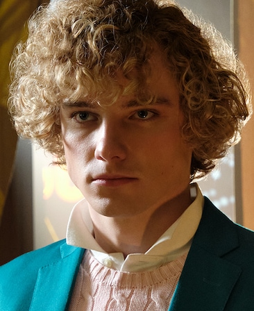 FX's The Shards Graham Campbell as Thom Wright wearing a teal suit and light pink sweater, with light highlight his leftside.
