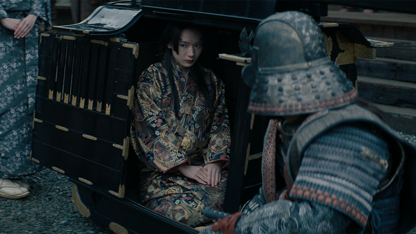 Jozen inspects a black palanquin with Fuji sitting inside
