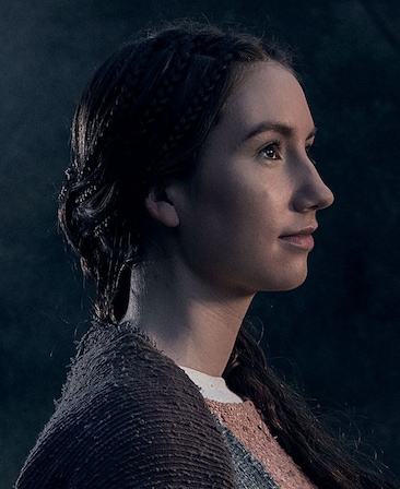 Sarah White headshot in layered brown robe with mauve and blue pattern with hair in elaborate braids over left shoulder