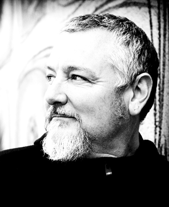 Randall Einhorn headshot wearing a black shirt and turning his head to the side