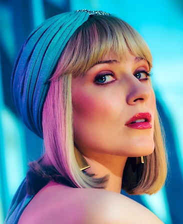 FX's The Shards Evan Rachel Wood as Liz Schaffer wearing a teal jeweled cap, with long gold triangular earrings. 