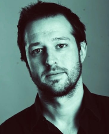 Headshot of executive producer Dave Andron wearing a black button up.