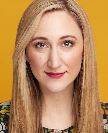 Darcy Fowler headshot wearing a floral top in front of a yellow background