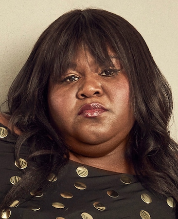 Gabourey Sidibe wearing a black top with gold detailing for AHS: 13