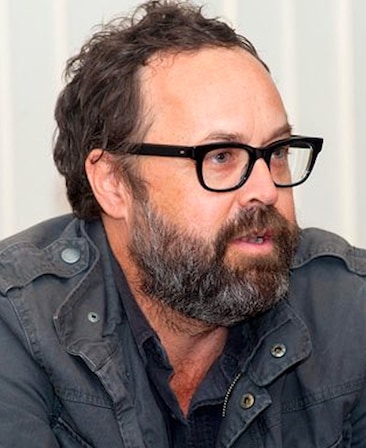 Scott Robertson headshot in a grey jacket and black glasses.