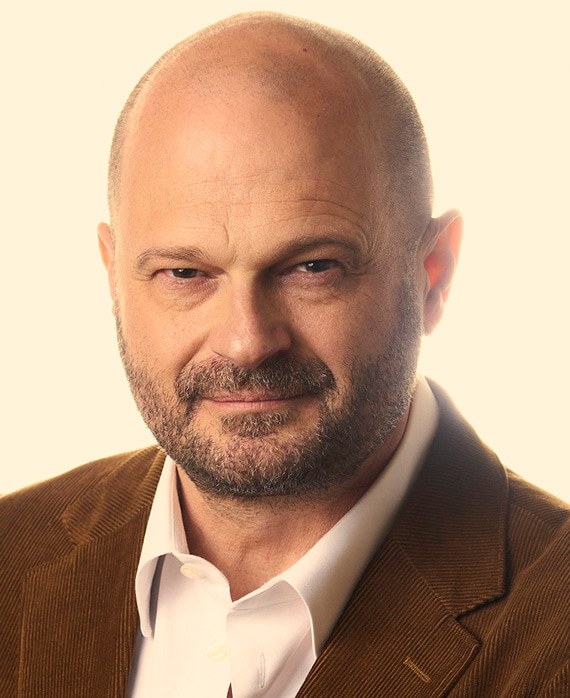 Headshot of executive producer Brad Simpson of FXs Love Story wearing a white button up and brown corduroy suit.