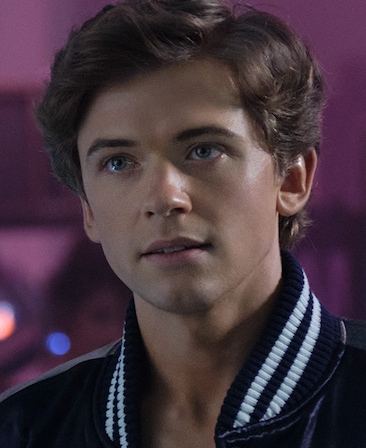 FX's The Shards Igby Rigney as Bret Easton Ellis wearing a sportswear jacket with purple background.