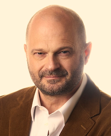 Headshot of FX's The Shards executive producer Brad Simpson wearing a white button up and brown corduroy suit.