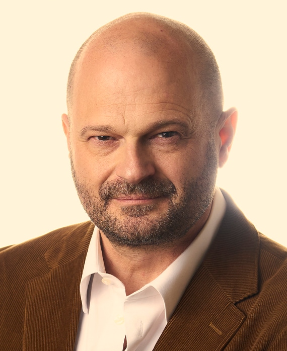 Headshot of FX's The Shards executive producer Brad Simpson wearing a white button up and brown corduroy suit.