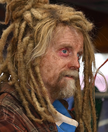 David Hornsby headshot wearing a red flannel shirt and dreads.